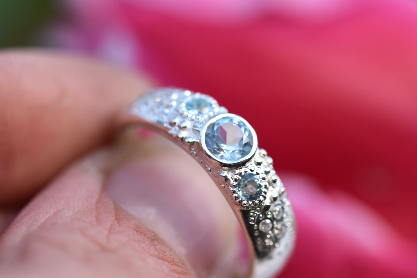Blue Topaz Sirens Ring Being Held